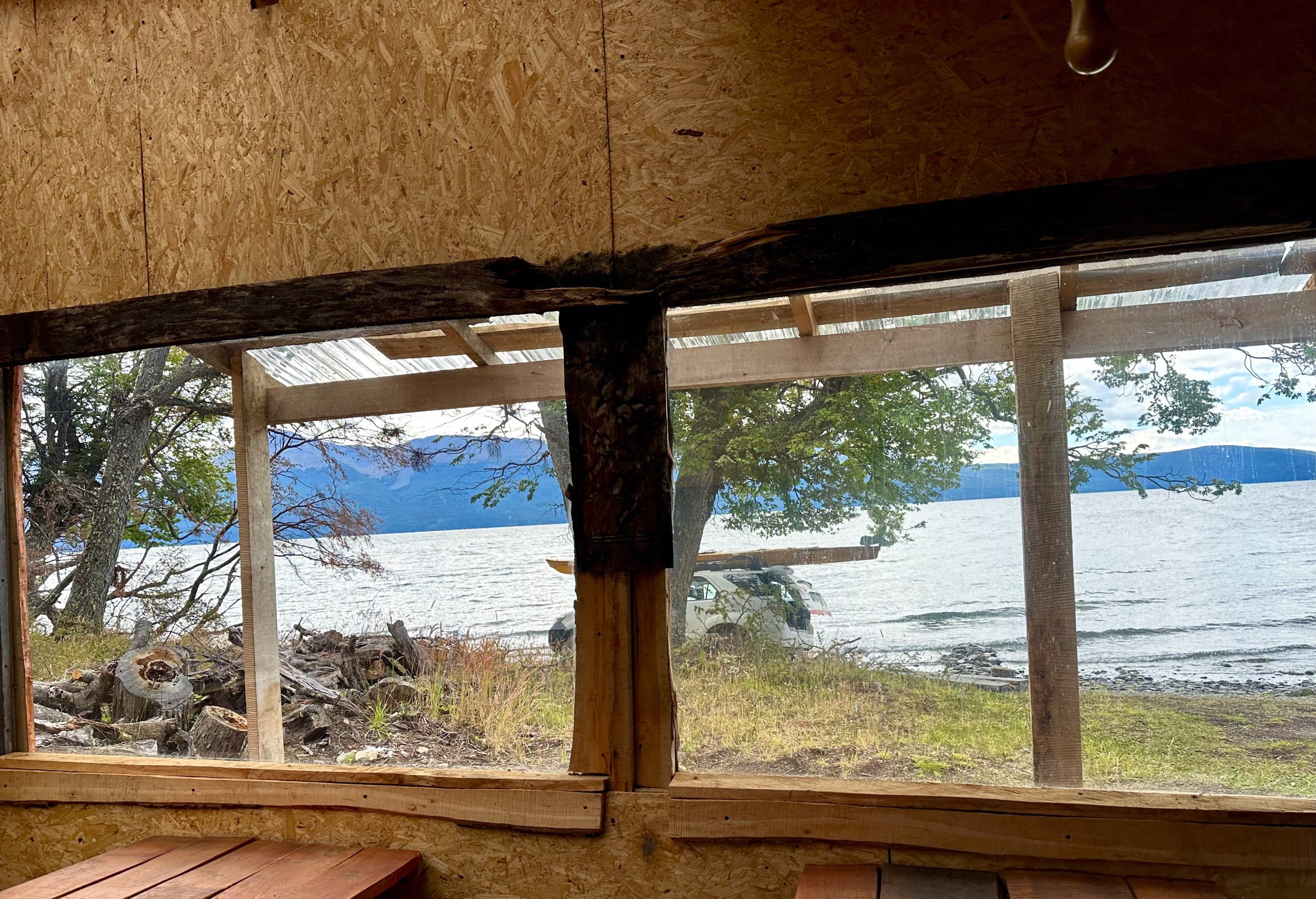 IMG_3819 A wooden window framing a lake and trees